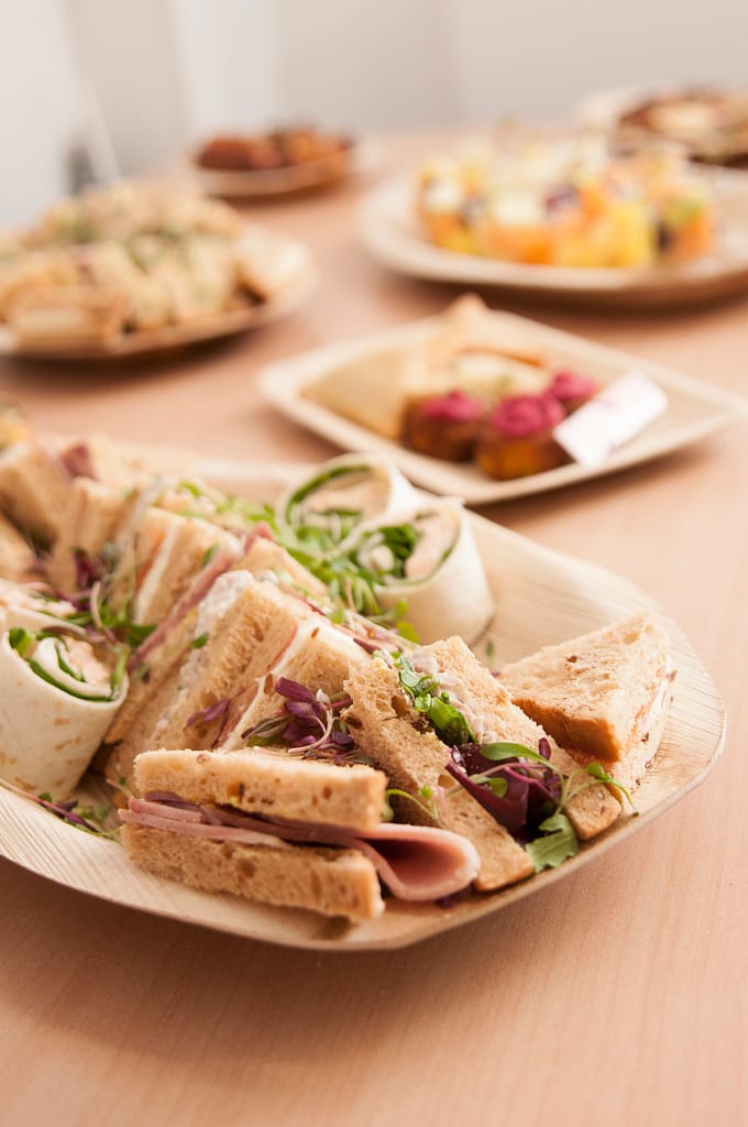 Platter of sandwiches, with more platters of food in the background
